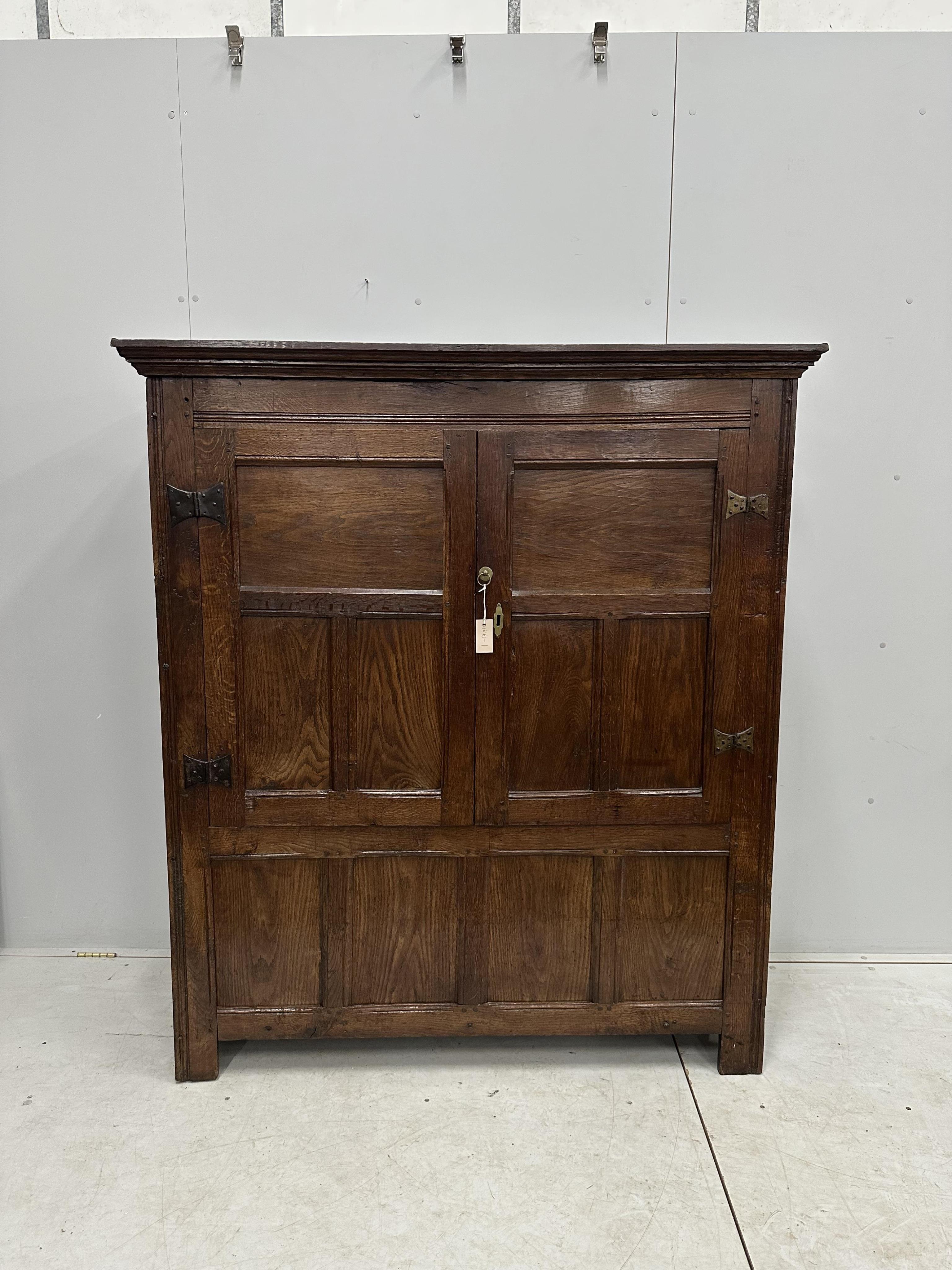 An 18th century and later panelled oak cupboard, width 140cm, height 159cm. Condition - good